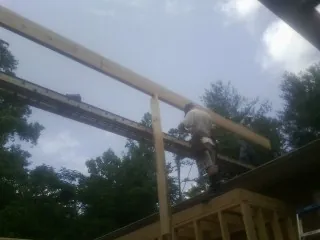 Carpenter setting a ridge beam over a new addition frame — Ice Dam Removal by Roofing Brothers in Marlboro