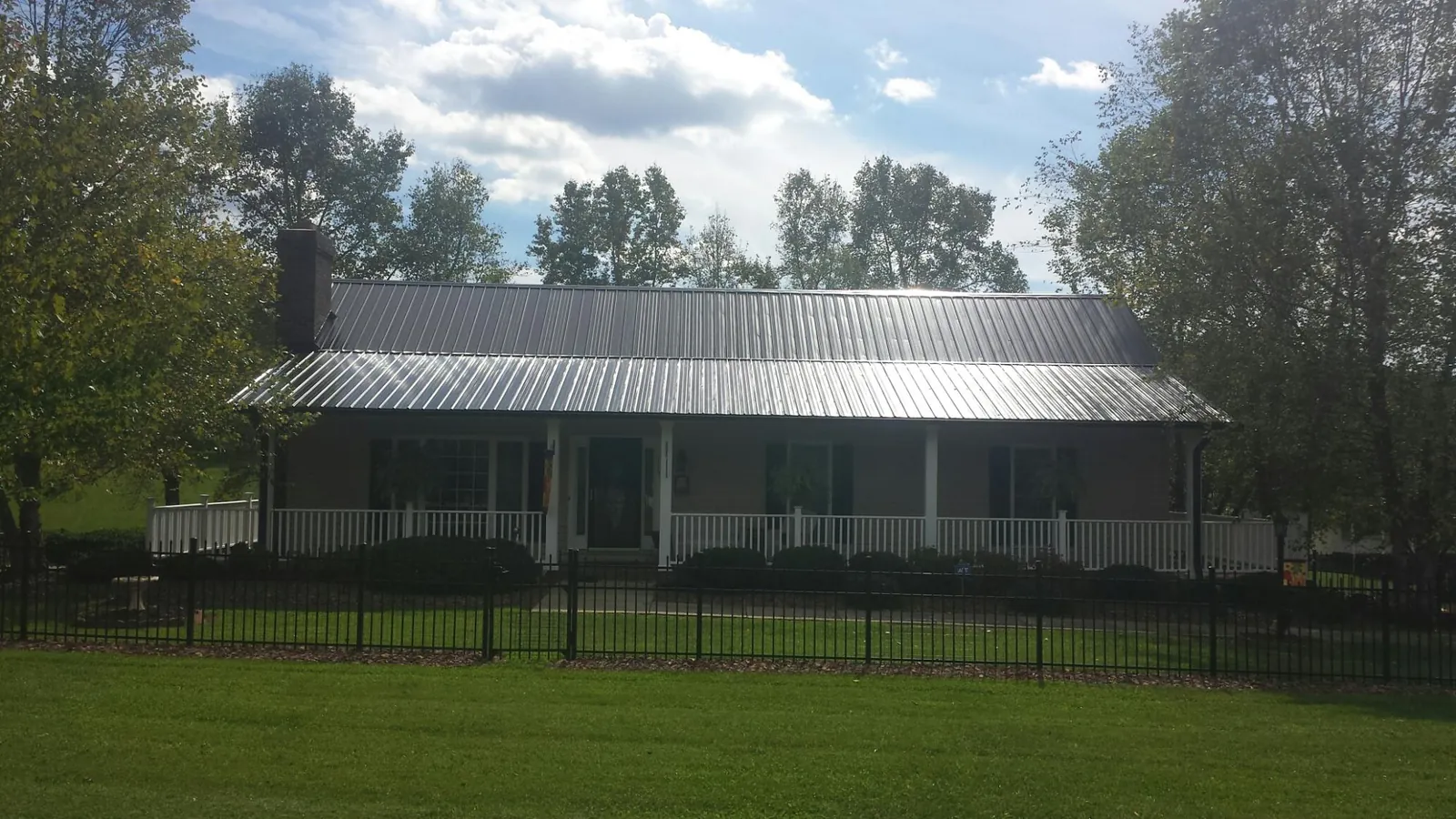 Gray metal roof on a brick ranch with a full width front porch — Gutter Guard Installation work by our crew in Marlboro